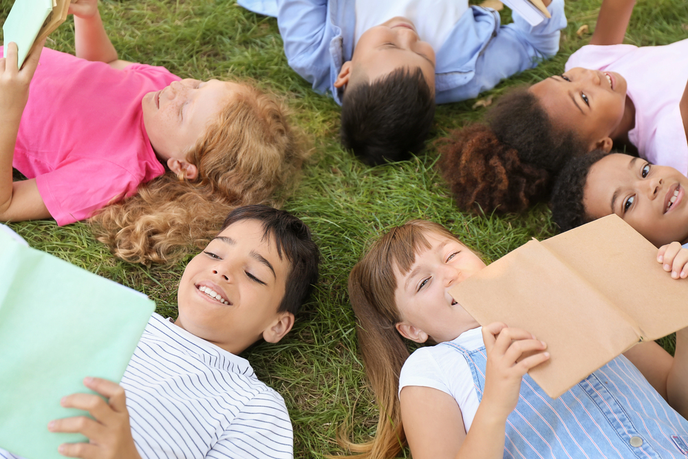 Bambini che leggono su un prato
