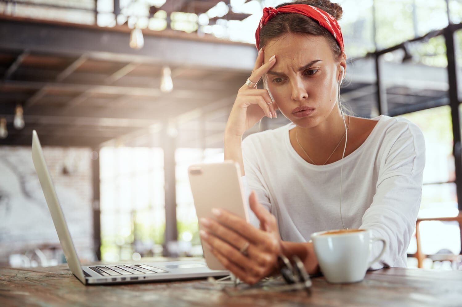 Nuova truffa bollo auto - Ragazza guarda preoccupata lo smartphone