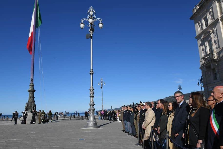 Il solenne alzabandiera ai Pili di piazza dell'Unità d'Italia.
